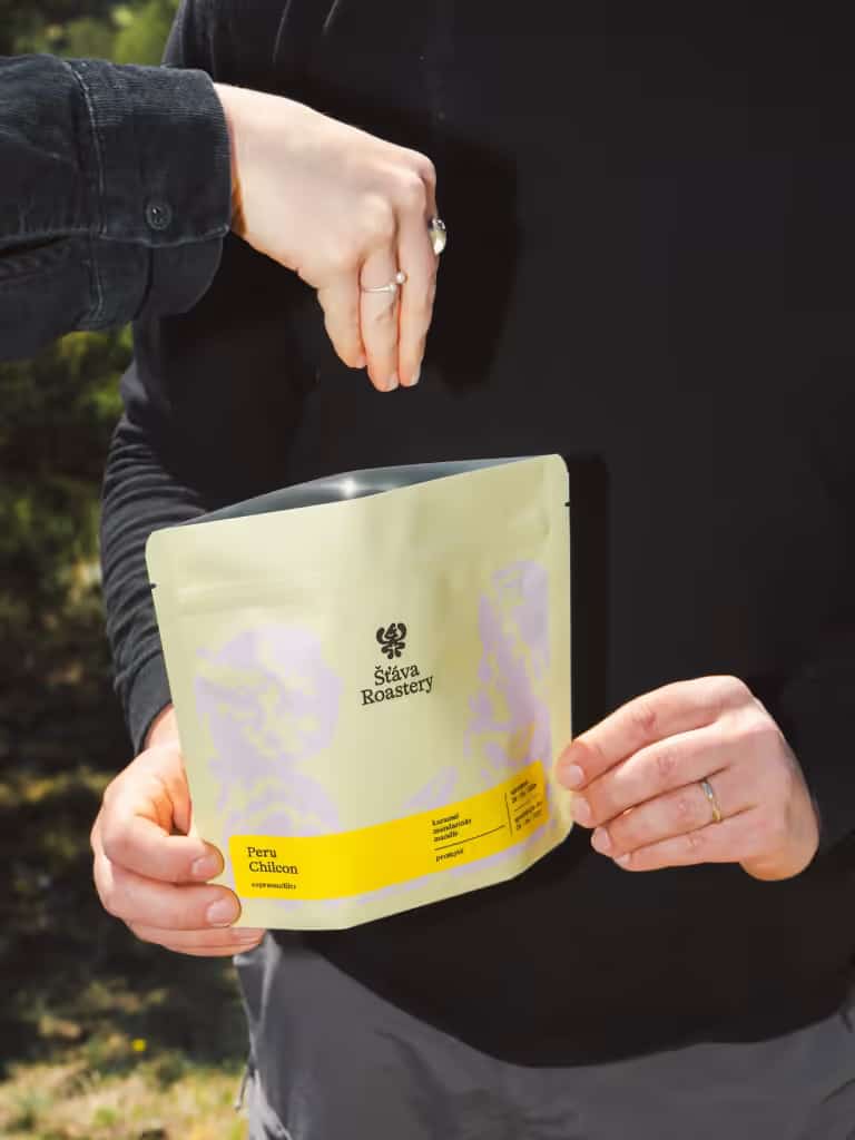 Sáček kávy Šťáva Roastery v rukou venku.